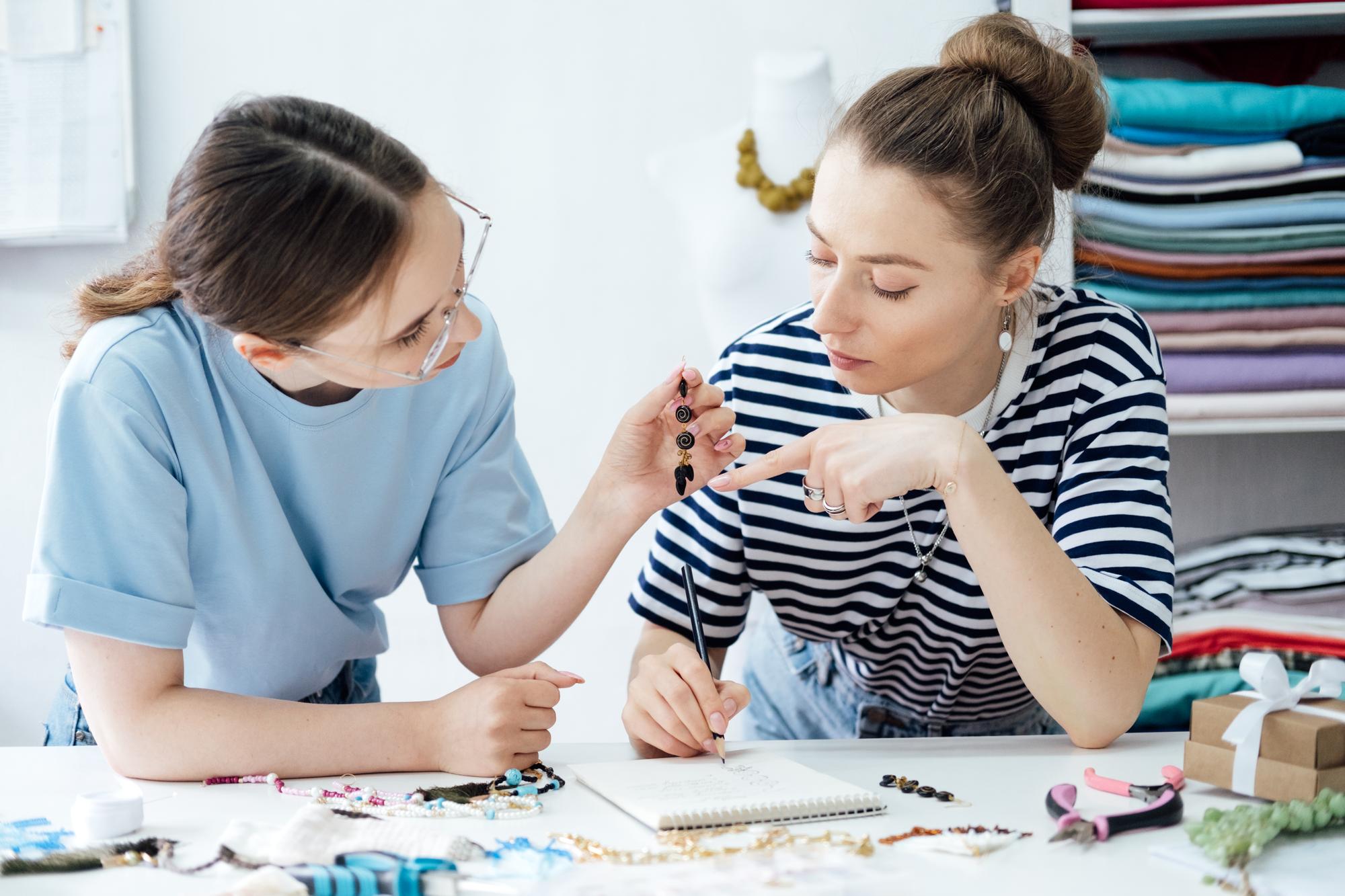 Dvi studentės dirba prie audinio studijoje